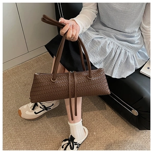 Detail showing the dark brown leather weave pattern and double zipper on the baguette bag