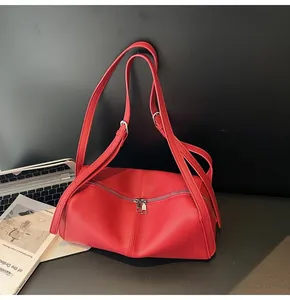 Dettaglio borsa a cuscino in pelle litchi rossa con doppia cerniera e manici