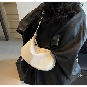 Detailed view of the white pebble leather texture and zip closure on hobo bag