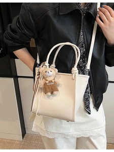 Beige lychee leather bucket bag with top handles and cute plush bear charm for women