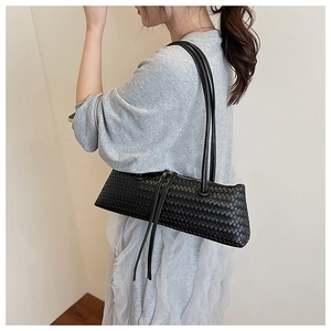 Detailed close-up of a black woven leather underarm bag with classic intrecciato texture