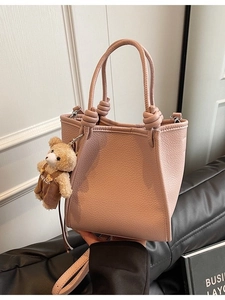 Pink lychee texture bucket bag with adjustable strap and cute teddy bear charm pendant