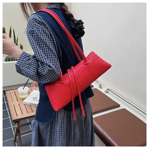 Detail of red woven leather shoulder bag showing the intricate handcrafted weave pattern