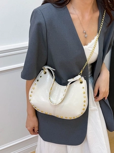 Chic cream leather crescent bag with gold studs, handle and chain strap on shoulder