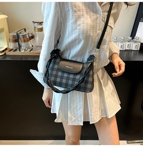Detailed view of women's checkered crossbody bag with leather flap and miao & she logo