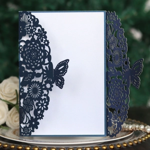 Dettaglio dell'invito di nozze blu navy con decoro floreale a farfalla intagliato a laser