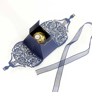 Elegant dark blue laser-cut favor box in dress shape with decorative ribbon for gifts