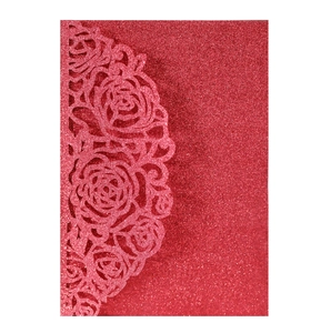 Detail of red glitter card with laser cut rose patterns for wedding invitations