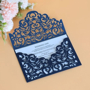 Laser cut navy blue wedding invitation suite with intricate filigree on a light background