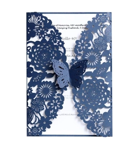 Dettaglio dell'invito di nozze blu navy tagliato al laser con pizzo floreale e chiusura a farfalla