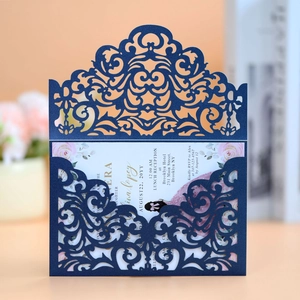 Detail of laser-cut navy blue wedding invitation cover with intricate floral patterns