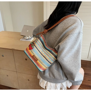 Vue détaillée du dos d'un sac seau tissé à rayures colorées avec breloques fraises