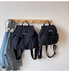 Detailed comparison of two black nylon backpacks in different sizes with drawstrings