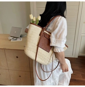Detail of straw tote bag with brown leather pocket and elegant white tulips inside