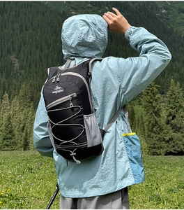 Outdoor backpack with elastic storage system and reflective strip shown in a forest setting