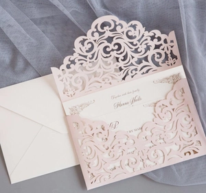 Detailed laser cut floral design on light pink wedding invitation with inner card