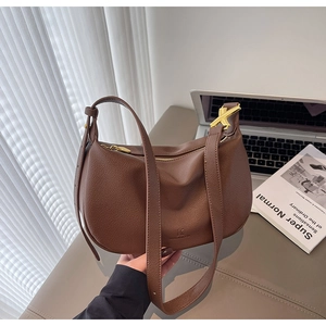 Detail of dark brown lychee leather hobo bag with gold hardware and logo embossing