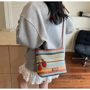 Vue détaillée du sac seau tissé multicolore avec breloques fraises et étiquette logo