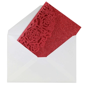 Close-up of glittery red laser-cut rose wedding invitation with white envelope