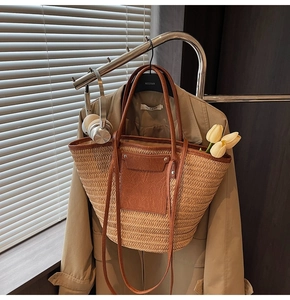Detail of straw tote bag with leather trim and pocket featuring tulips in a lifestyle setting