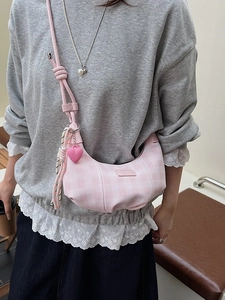 Pink and white checkered crescent crossbody bag with heart pendant and knotted strap