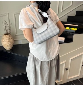 Silver checkered hobo bag worn by model, showing its size and curved shoulder strap