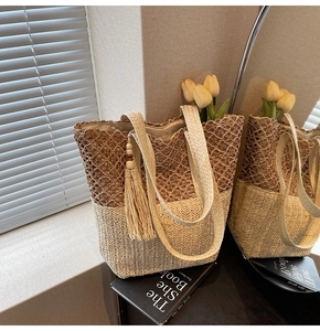 Close-up of woven tote bag with contrast stitching, fringe tassel and wooden beads