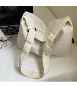 Detail of wide adjustable shoulder strap and BNT embroidery on cream canvas tote bag