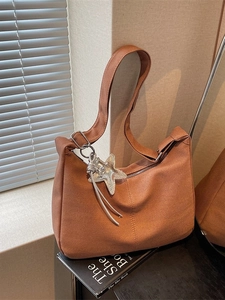 Caramel herringbone woven crescent bag with star pendant and wide shoulder strap