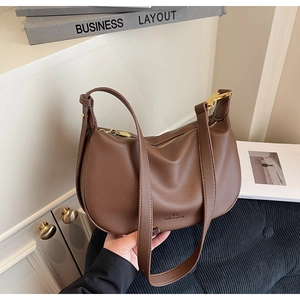 Detail of dark brown pebble leather hobo bag with gold hardware and logo embossing