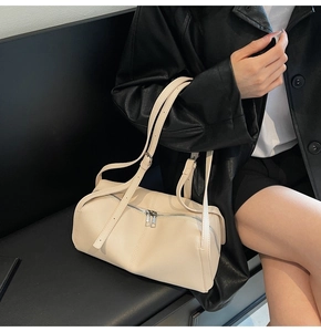 Dettaglio borsa beige in pelle martellata con doppia cerniera e finiture in metallo argento