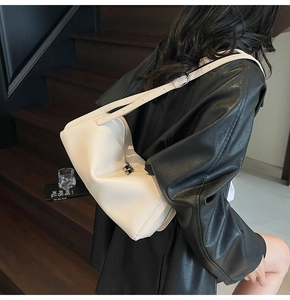 Dettaglio della pelle litchi bianco crema e hardware argento di una borsa a spalla