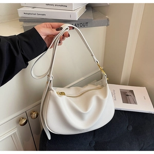 Detail of white lychee leather texture and golden zipper on this minimalist shoulder bag