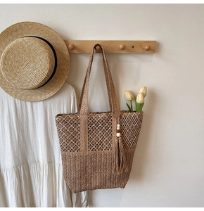 Detail of woven straw tote bag with intricate hollow mesh and wavy texture patterns