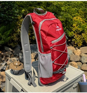 Detail of red outdoor cycling backpack with breathable mesh straps and elastic cord system