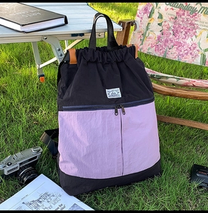 Detail of color-block drawstring backpack with durable nylon fabric in outdoor camping setting