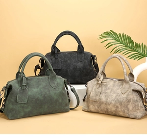 Detailed display of vintage pillow handbags in dark green, black, and taupe matte leather