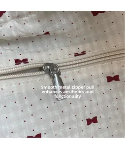 Close-up of smooth metal zipper head on a red floral mesh shoulder bag for summer