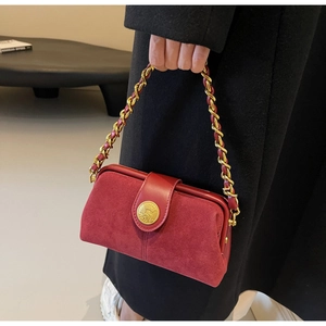 Detail of red frosted suede doctor bag with golden embossed buckle and chain strap