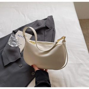 Close-up of white lychee pattern leather hobo bag with gold zipper and brand logo