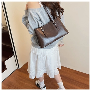 Rear view of a model wearing a glossy brown leather tote bag for professional commuters