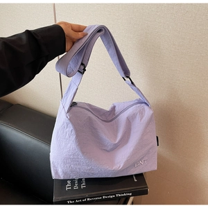 Vue détaillée du sac en nylon lilas avec broderie BNT et bandoulière réglable