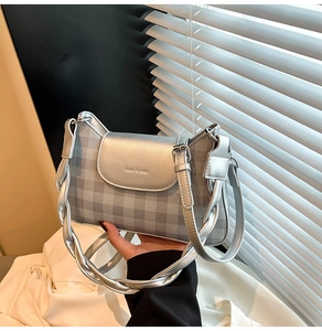 Detail of silver checkered underarm bag with miao & she branding and metallic woven handle