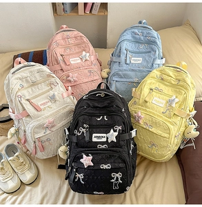 Detailed view of quilted student backpacks in five colors with bow embroidery and star patches