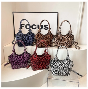 Multiple colors of leopard print bucket bags displayed on a modern minimalist staircase
