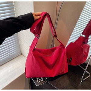 Détail du sac cabas en toile rouge avec broderie BNT et bandoulière réglable