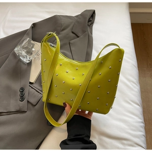 Detail of lime green hobo bag with silver studs and adjustable shoulder strap
