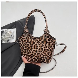 Detail of leopard print tote bag with circular knot handles and silver metal hardware