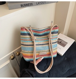 Détail d'un sac seau tissé à rayures colorées avec poignées nouées et étiquette en cuir logo