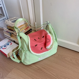 Détail du sac à bandoulière pastèque vert clair avec rabat rose et breloque en peluche